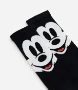 Medias de caña larga color negro, confeccionadas en algodón, con estampado del rostro de Mickey Mouse en la parte superior.