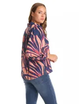 Camisa de gasa con estampado de hojas en tonos azul y coral, con cuello camisero, cierre frontal de botones y mangas tres cuartos con puños fruncidos.