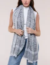 Pashmina rectangular gris con diseño jacquard, destellos de hilos metalizados y flecos en los extremos.