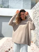 Sweater de tejido de punto en color beige, con diseño holgado y corte oversize, de manga larga y cuello redondo.