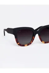 Lentes de sol Tiwi modelo Kerr con diseño de montura combinada, parte superior en negro mate y parte inferior con estampado carey. Lentes oscuras con protección UV.