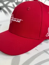 Gorra de béisbol roja con logo bordado en blanco en el frente.