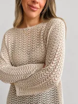 Sweater de tejido calado color beige, con escote redondo, mangas largas y corte amplio y relajado.