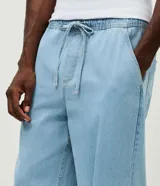 Pantalón de jean azul claro con calce baggy relaxed, cintura elástica con cordón de ajuste y bolsillos laterales.