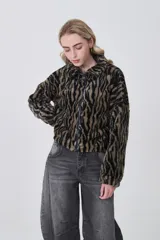 Campera de corderito con estampado animal print, de manga larga, cuello alto y cierre frontal completo.