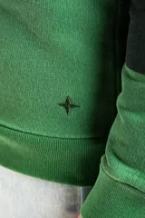 Sweater de punto con diseño de rayas horizontales anchas en tonos verde oscuro y verde claro, con cuello tipo polo y cierre frontal parcial. Presenta mangas largas con puños elásticos y un pequeño bordado en la parte inferior.