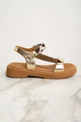 Sandalia de cuero color dorado con tiras marrón y estampado animal print, con plataforma marrón.