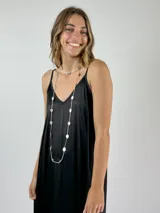 Collar largo plateado con eslabones finos y dijes circulares planos.