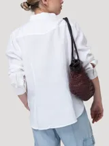 Blusa de lino orgánico color blanco, con cuello camisero, cierre frontal con botones y mangas largas.