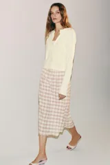 Falda midi recta de tiro medio con estampado a cuadros en tonos rosados y blancos sobre base beige, confeccionada en hilatura con mezcla de viscosa. Cuenta con cintura elástica ajustable con cordones y bajo recto.