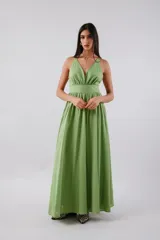 Vestido midi de color verde, con escote en V profundo, banda ancha bajo el busto y falda amplia con gran volumen. Presenta espalda baja y cierre invisible.