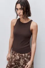 Musculosa de calce ajustado color rojo, confeccionada en algodón con elastano. Presenta escote redondo alto y textura acanalada.