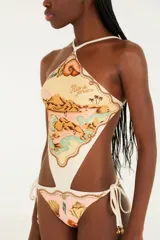Traje de baño enterizo con diseño cut-out, cuello halter y estampado temático de paisajes y elementos marinos. Presenta tiras laterales ajustables en la parte inferior.