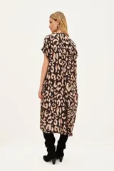 Vestido midi de corte holgado con estampado animal print, cuello en V y mangas cortas. Cuenta con bolsillos laterales.