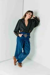 Pantalón de vestir azul eléctrico con pinzas, tiro alto, corte ancho y cinturón marrón con hebilla metálica con forma de sol.