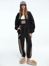 Campera tipo bomber color negro, con cierre frontal, cuello redondo, puños y ruedo elásticos, y bolsillos laterales con solapa.