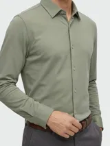 Camisa de vestir slim fit de tejido stretch color verde militar, con cuello camisero, manga larga y cierre frontal de botones.