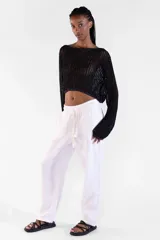Sweater crop de manga larga tejido con hilos de distintos tonos y lurex que aporta brillo sutil, con escote amplio y detalle de moneda metálica Polonio en color rose gold.