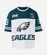 Remera de corte oversized con diseño deportivo de los Philadelphia Eagles. Presenta cuello redondo, mangas cortas con detalles de rayas y estampa frontal del equipo. Confeccionada en algodón.