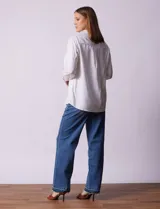 Camisa color verde oliva de lyocell, marca Cyrus. Tiene cuello con solapa, abertura central con botones, mangas 3/4 regulables con presilla y botón, y dos bolsillos delanteros aplicados.