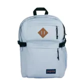 Mochila JanSport modelo Main Campus en color celeste. Cuenta con dos compartimentos principales con cierre, un bolsillo frontal con cierre, correas de compresión laterales con hebillas y un bolsillo lateral de malla para botella. Incluye un parche decorativo en el frente y el logo de la marca en la parte inferior.