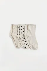 Pack de tres pares de medias cortas de algodón peinado. Incluye un par con estampado de puntos dorados, un par con estampado de corazones negros y un par con textura de corazones en relieve.