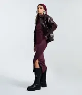 Vestido midi de manga larga en color bordó, con diseño ajustado al cuerpo, cuello redondo y detalle de pliegues asimétricos en uno de los hombros. Presenta una abertura lateral en el ruedo.