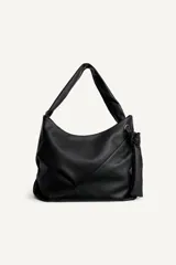 Bolso tipo shopper de hombro confeccionado en piel de alta calidad, con diseño minimalista y cierre principal mediante cremallera. Cuenta con un bolsillo interior con cierre y asa ajustable.