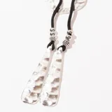 Collar con cordón negro, dije circular plateado y colgantes con forma de lágrima texturizadas.