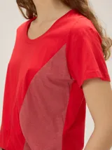 Remera de manga corta con diseño colorblock en tonos blanco, negro y beige, escote redondo y costuras verticales decorativas en el centro.