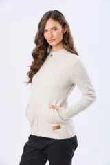 Campera tejida de punto con cierre frontal completo, cuello tipo mao y puños acanalados. Presenta un parche decorativo de cuero sintético en la parte inferior y un diseño de textura suave y abrigada.