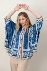 Camisa de seda con estampado tipo pañuelo en tonos azules y celestes, con diseño amplio y mangas murciélago anchas.
