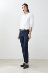 Pantalón de vestir azul marino, de corte recto, con bolsillos laterales y traseros. Se ajusta a la cintura con cinturón de cuero con estampado animal print.