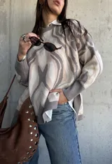Sweater de punto con diseño abstracto de líneas orgánicas en tonos gris y beige, cuello redondo, manga larga con puños ajustados y corte holgado.