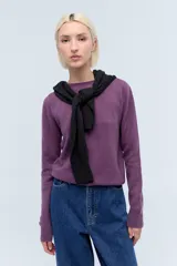 Sweater de punto color lila, de corte clásico con cuello redondo y mangas largas con puños acanalados.