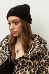 Gorro de lana tejido en ochos con vuelta acanalada y parche frontal con logo de la marca Daniel Cassin.