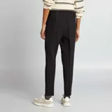 Pantalón negro de vestir, corte pitillo, con bolsillos laterales y traseros.