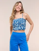 Top crop de viscosa con estampado abstracto en tonos azul y blanco, con pechera integramente elastizada en punto smock, escote recto y breteles finos.