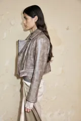 Chaqueta corta de cuero sintético color marrón con cierre cruzado y cuello con solapas.