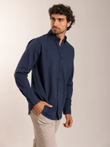 Camisa de lino y algodón color azul marino, de corte regular fit, manga larga y cuello con botones.