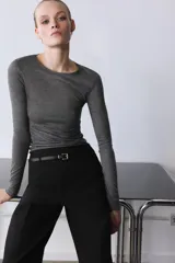 Pantalón culotte negro de tiro medio con trabillas y cinturón fino efecto piel con hebilla metálica. Presenta raya planchada y cierre de cremallera oculta en la costura.