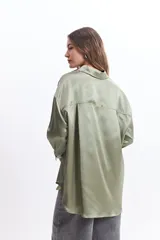 Camisa color verde oliva de manga larga confeccionada en tela satinada.