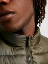 Chaleco puffer color verde oliva con cierre frontal y bolsillos laterales.