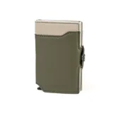 Billetera tarjetero automática con estructura de aluminio y revestimiento de cuero bicolor en tonos verde oliva y beige. Cuenta con un cierre de broche a presión y el logo de la marca grabado en la parte inferior.