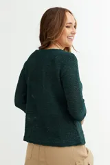 Cardigan de tejido de punto color naranja, con mangas tres cuartos y cierre frontal mediante un único botón en el cuello.