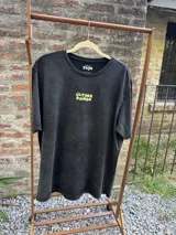 Remera blanca de manga corta con cuello redondo y estampado amarillo con la frase "Última Ronda".