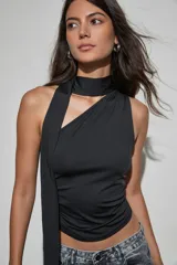 Top negro sin mangas con diseño de cuello halter y detalle de tira larga lateral. Presenta un ajuste entallado con frunces en los laterales.