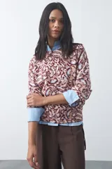 Sweater de punto con diseño de estampado animal print abstracto en tonos tierra y azul claro. Presenta cuello redondo a la base, mangas largas levemente amplias y terminaciones acanaladas en puños y ruedo.
