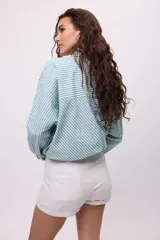 Short de corte sastrero color turquesa, con cierre frontal de botón y bolsillos laterales.