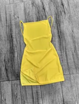 Vestido corto amarillo con breteles finos y espalda descubierta.